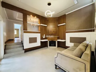 Sala de estar com painéis de madeira e lareira em um imóvel no Brasil.