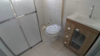 Foto de um banheiro com piso cerâmico e armário de madeira.