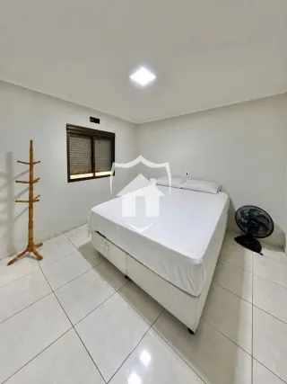 Quarto com cama e piso de cerâmica branca.