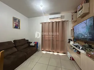 Sala de estar com sofá e televisão em um imóvel no Brasil.