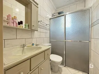 Foto de um banheiro com revestimento de azulejo claro.