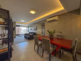Sala de jantar com mesa vermelha e cadeiras em um imóvel no Brasil.