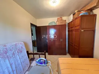 Quarto com armário de madeira e cama no interior de uma residência.