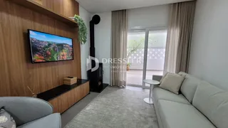 Sala de estar com sofá e televisão em um apartamento no Brasil.