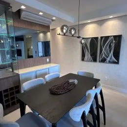 Foto de um ambiente interno com mesa de jantar e cadeiras.