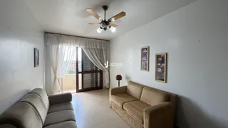Sala de estar com sofá e janelas claras.