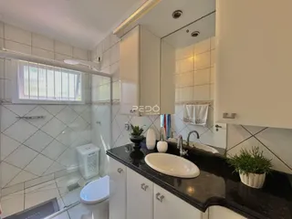 Foto de um banheiro com revestimento de azulejos brancos.