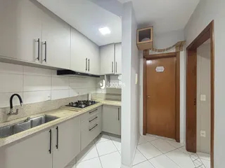 Foto de uma cozinha com armários brancos e bancada clara.