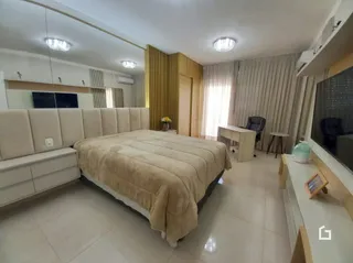 Quarto com cama grande e paredes brancas.
