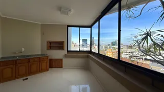 Sala de estar com grandes janelas que oferecem uma vista da cidade.