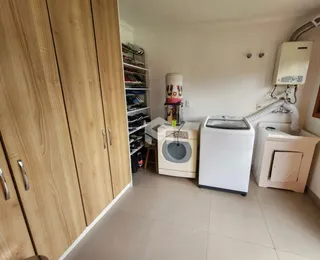 Quarto com armários de madeira e piso cerâmico claro.