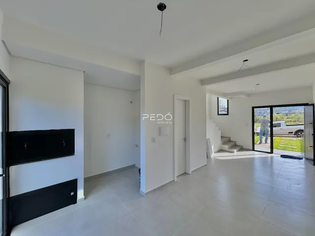 Sala de estar com piso claro e paredes brancas.