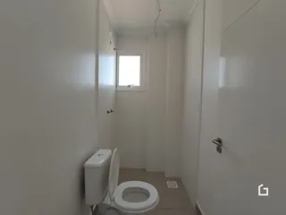 Vista de um corredor interno com um vaso sanitário.