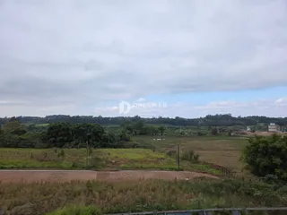 Paisagem de campo com vegetação e campos abertos.