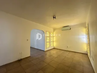 Vista interna de um corredor com piso de cerâmica e uma abertura arqueada.