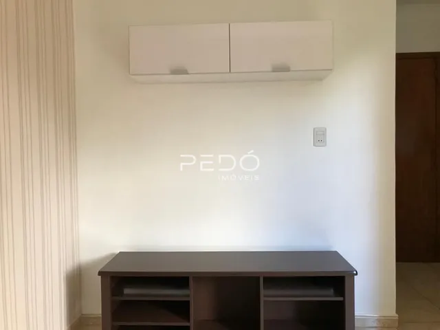 Parede interna com um móvel de madeira e interruptor de luz.