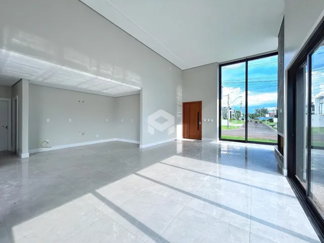 Ambiente interno de uma sala ampla com piso claro.