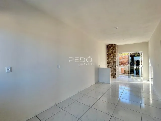 Hall de entrada com piso de porcelanato claro e paredes brancas.