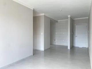 Foto de um corredor interno com paredes brancas e piso claro.
