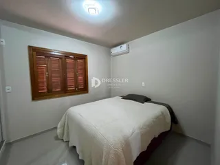 Quarto com janela de madeira e cama coberta.