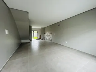 Interior de um espaço amplo com paredes cinzas e piso de concreto.