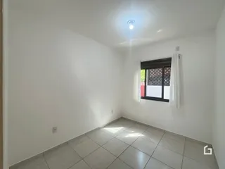 Foto de um cômodo interno com paredes brancas e piso de cerâmica.