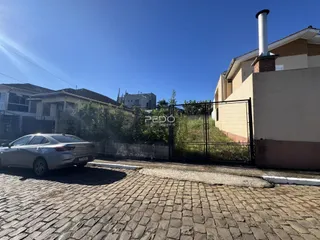 Fachada de uma residência em Lajeado, Brasil, com cerca e paisagismo.