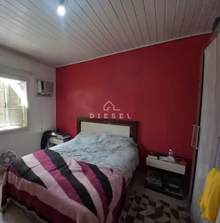 Quarto com cama e parede vermelha.