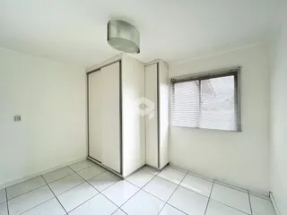 Hall de entrada com piso de cerâmica branca e armários embutidos.