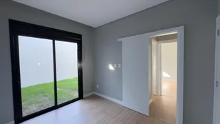 Uma sala de estar com porta de vidro que oferece vista para um gramado.