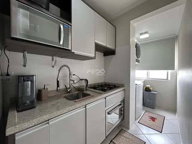 Cozinha moderna com armários brancos e bancada de granito.