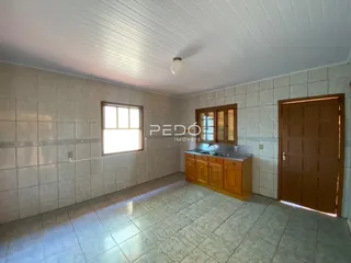 Foto de uma sala de estar com piso de cerâmica e paredes de azulejo claro.