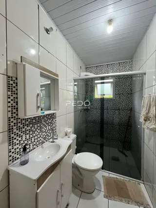 Foto de um banheiro com azulejos brancos e detalhes em preto.