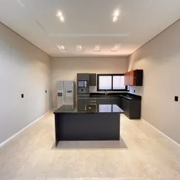 Esta é uma cozinha moderna com armários escuros e iluminação clara.