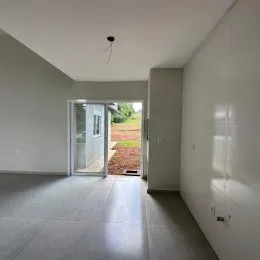 Hall de entrada com piso claro e paredes brancas.