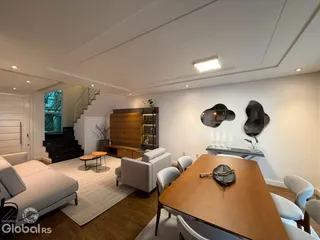 Sala de estar moderna com piso de madeira e escadaria em um apartamento.