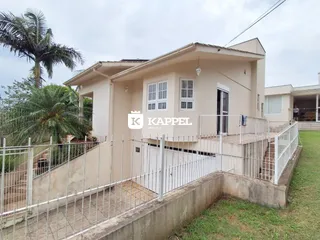 Fachada de uma residência em Lajeado, Brasil, com cerca e jardim na frente.