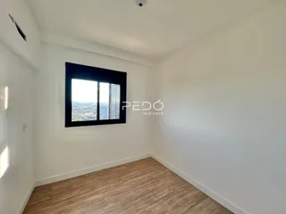 Ambiente interno de uma sala com vista para a paisagem urbana.