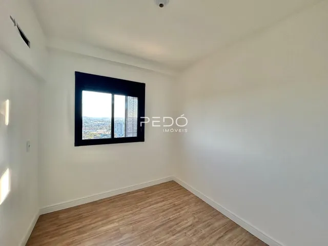 Ambiente interno de uma sala com vista para a paisagem urbana.