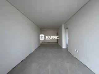Corredor interno de uma residência com paredes brancas e piso cinza.