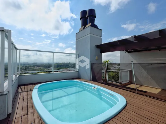 Uma piscina com deck de madeira em uma área externa.