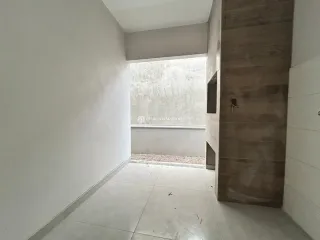 Vista de um corredor interno com paredes brancas e piso claro.