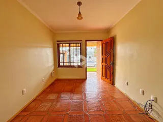 Hall de entrada com piso de cerâmica terracota e janela.