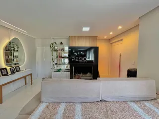 Sala de estar moderna com sofá e lareira em um imóvel no Brasil.