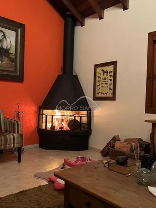 Sala de estar com lareira preta e paredes laranja.