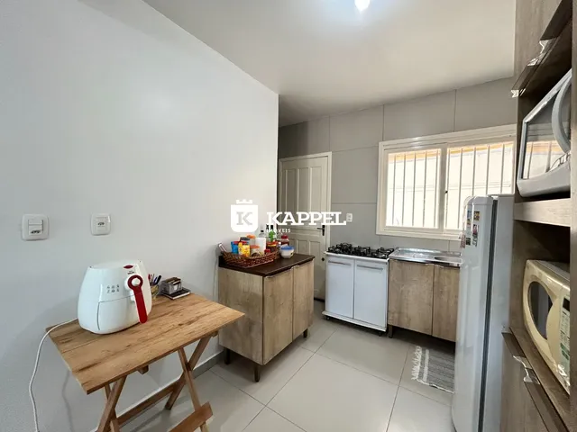 Foto de uma cozinha com armários e eletrodomésticos visíveis.