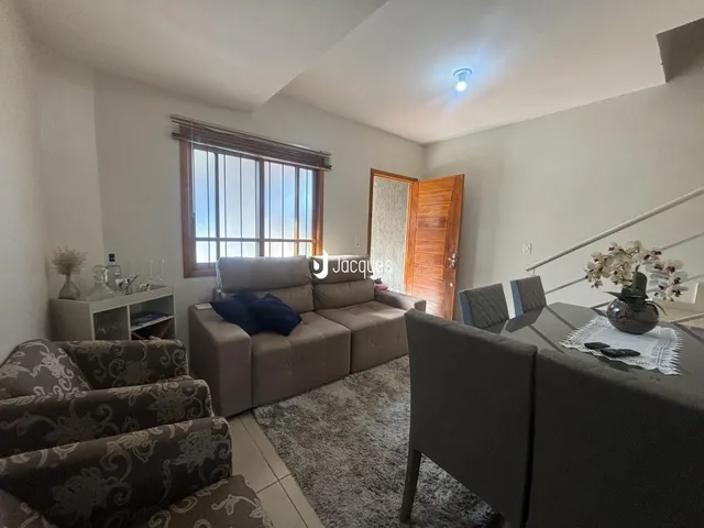 Sala de estar com sofá e piso claro em um imóvel no Brasil.