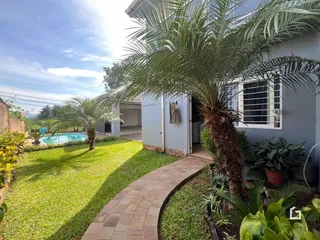 Vista da fachada de uma residência com jardim e piscina em Lajeado, Brasil.