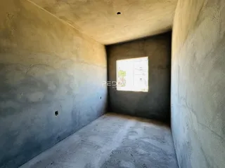 Foto de um corredor interno com paredes de concreto aparente.