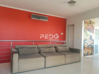 Sala de estar com parede vermelha e sofá claro.